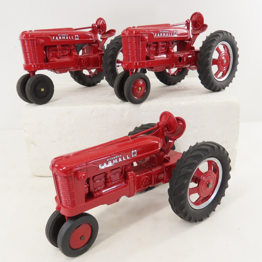 3 Repainted Hubley IH McCormick Farmall Tractors: 3 Repainted Hubley IH McCormick Farmall Tractors - nearly identical- 1 is missing foot pedal, and 2nd has hole through engine above pedal. all 3 have Hubley marked wheels, 1/16 diecast, LOT SIZE:
