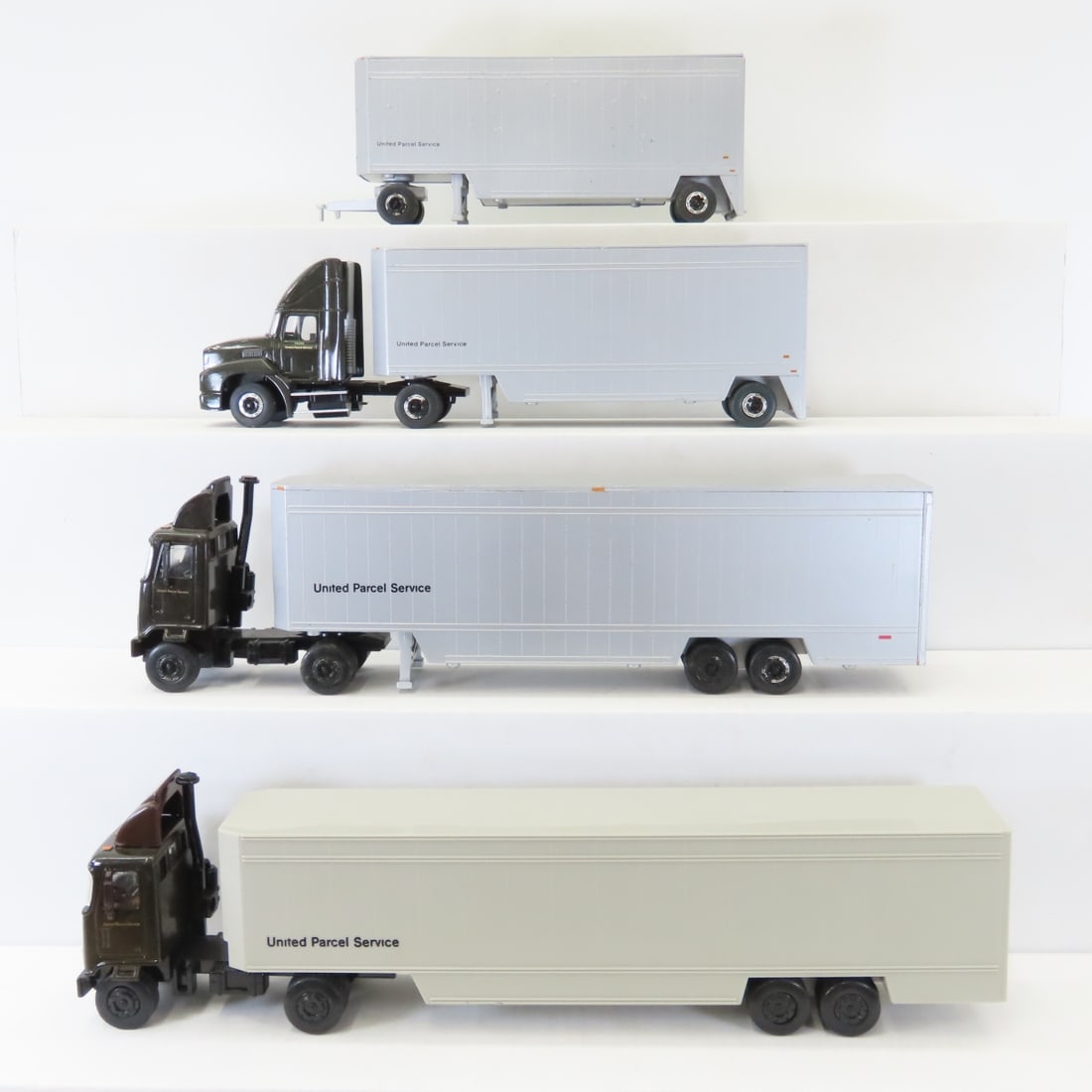 2 UPS Semi-Trucks & 1 Double Trailer Truck: 2 UPS Semi-Trucks & 1 Double Trailer Truck - 1 all plastic, other 3 are all heavy metal trailers, all made in China. 1/64 scale. LOT SIZE: 14x10x5" 9 LBS All information and photos, which are part of