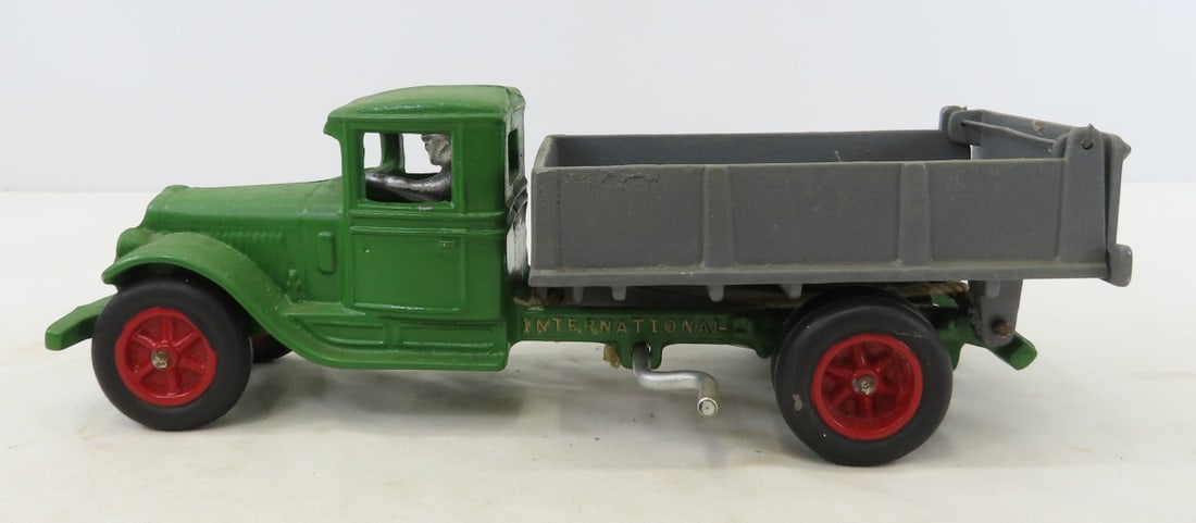 Repainted International Cast Iron Dump Truck: Repainted International Cast Iron Dump Truck - with driver, rope on crank works dump. LOT SIZE: 11x4x4" 4 LBS All information and photos, which are part of the description, are intended to be as