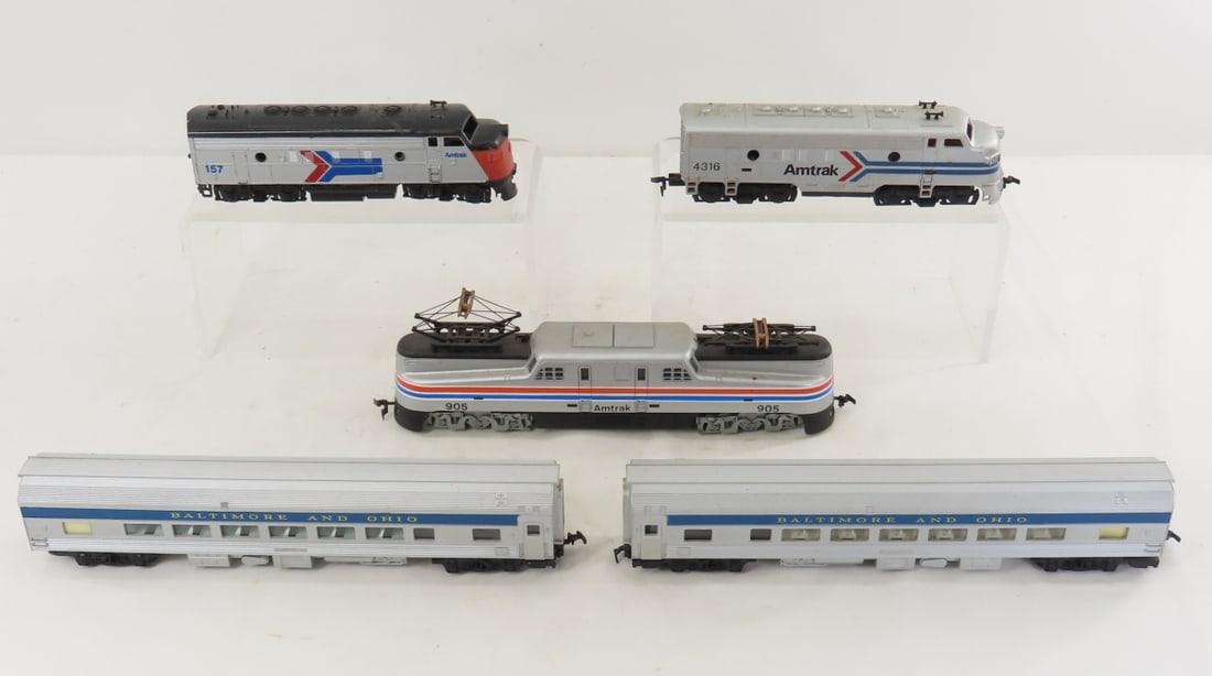 3 HO Scale Amtrak Engines and 2 Passenger Cars: 3 HO Scale Amtrak Engines and 2 Passenger Cars - Tyco Amtrak electric 905 locomotive, Tyco diesel 4316 and unbranded diesel, 2 Tri-Ang B&O passenger cars. LOT SIZE: 10x9x3" 3 LBS All information and