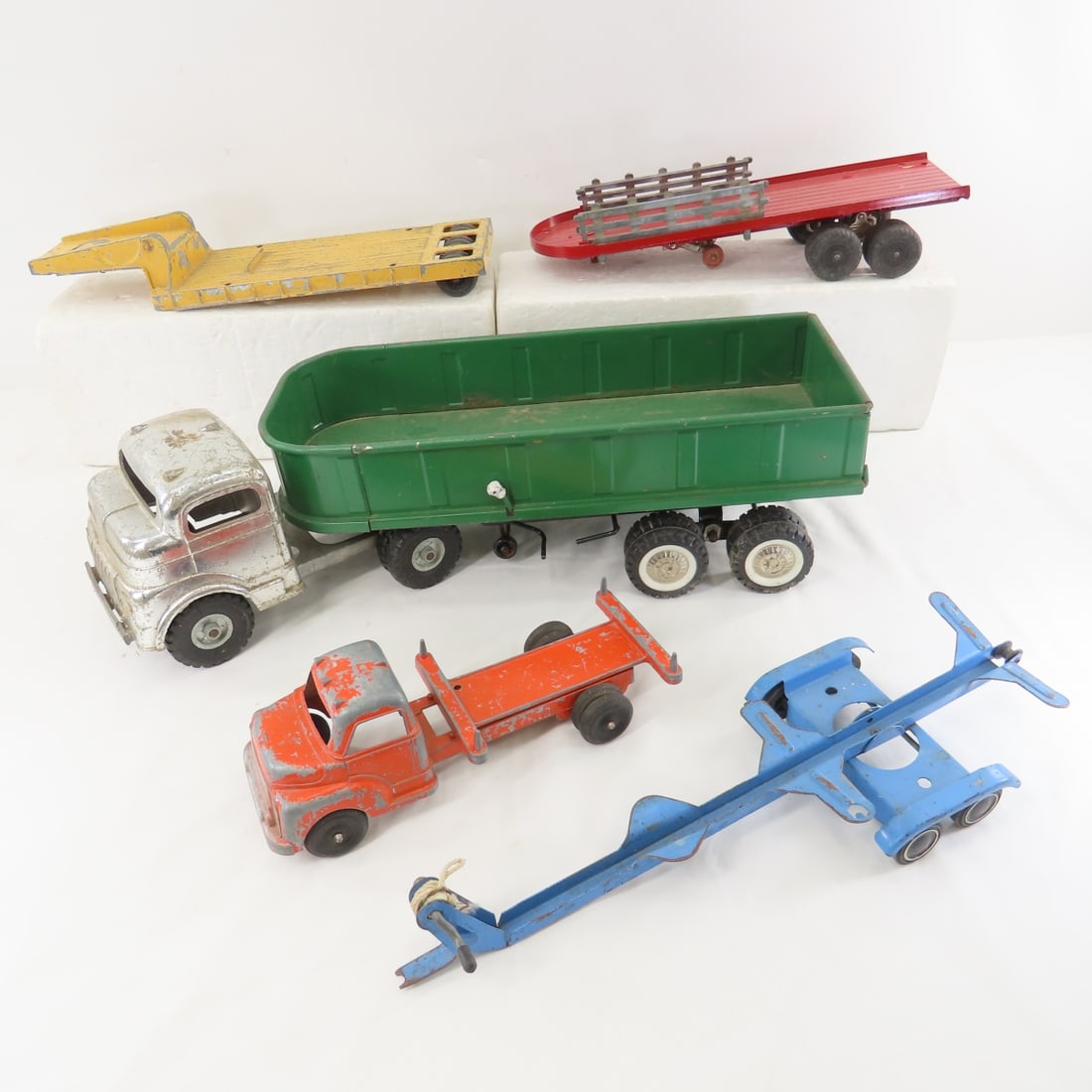 Structo, Hubley & Pressed Steel Toys: Structo, Hubley & Pressed Steel Toys - 1/18 Structo silver truck with hydraulic green trailer (hydraulic works but is slow), 1/24 Structo log hauler, Hubley yellow flat bed trailer, repainted red