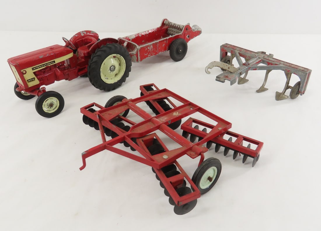 ERTL International 404 Tractor & Implements: ERTL International 404 Tractor & Implements - tractor with 3 pt hitch, manure spreader has loose wheel- wheels are Tootsie toy, ERTL Cockshutt disc harrow, and 4 bottom plow (Hubley?), 1/16 sale, LOT