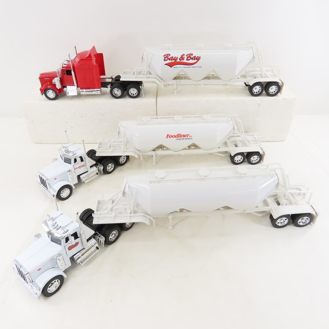 2 Peterbilt & 1 Kenworth Tractors with 3 tankers: 2 Peterbilt & 1 Kenworth Tractors with 3 tankers - 1 Bay & Bay, 1 Foodliner, 1 no brand, all made in China and plastic. LOT SIZE: 19x14x6" 5 LBS All information and photos, which are part of the