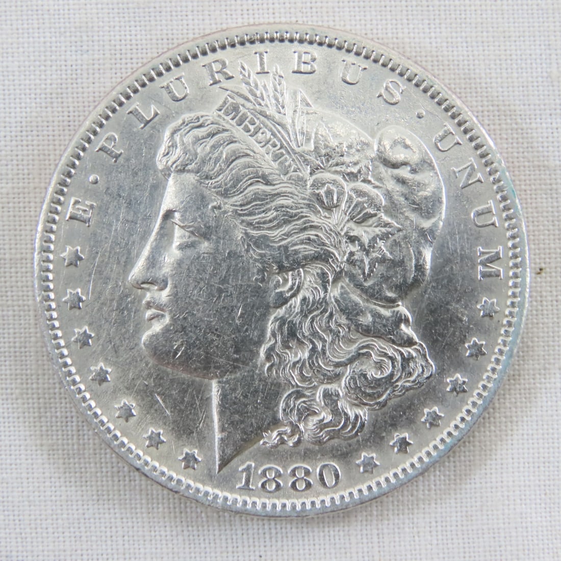 1880 Morgan Silver Dollar: 1880 Morgan Silver Dollar - Lot Size 2x2x1" 1 LB All information and photos are intended to be as accurate as possible, but errors are possible. No item may be returned or refused based on this