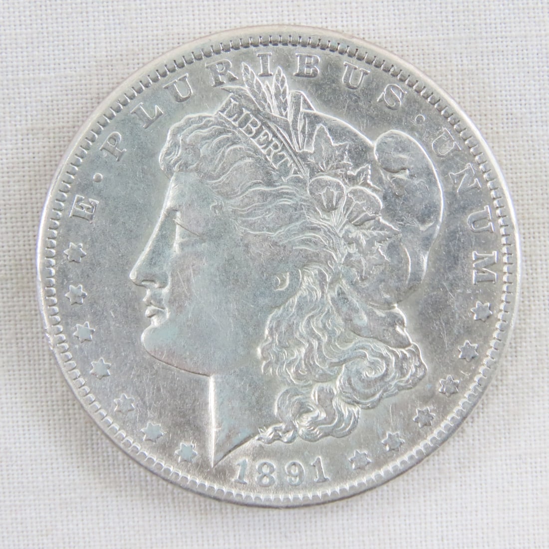 1891 Morgan Silver Dollar: 1891 Morgan Silver Dollar - Lot Size 2x2x1" 1 LB All information and photos are intended to be as accurate as possible, but errors are possible. No item may be returned or refused based on this