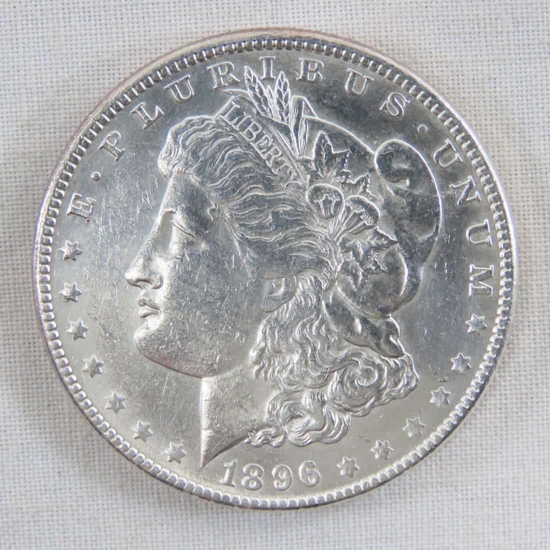 1896 Morgan Silver Dollar: 1896 Morgan Silver Dollar - Lot Size 2x2x1" 1 LB All information and photos are intended to be as accurate as possible, but errors are possible. No item may be returned or refused based on this