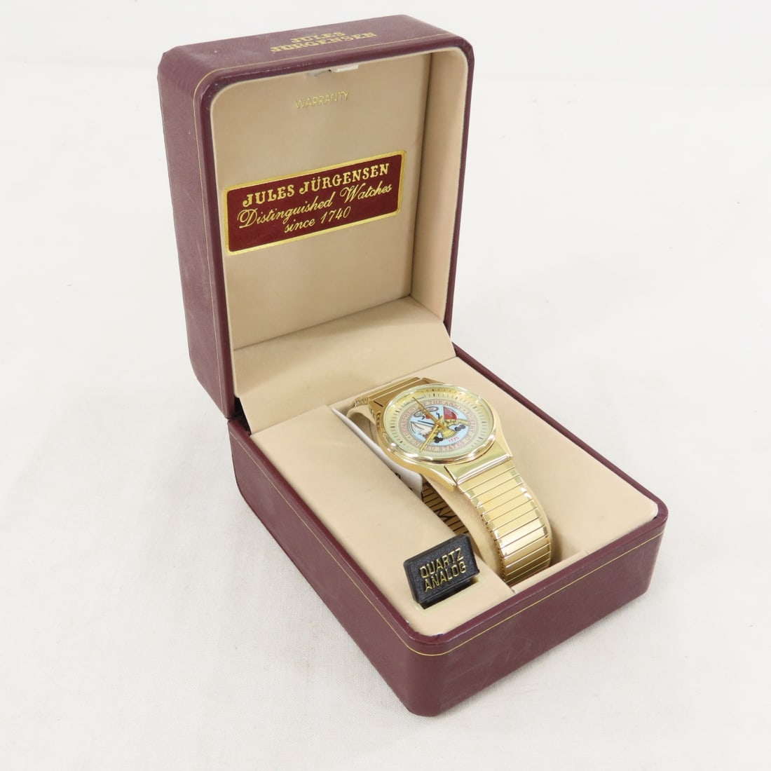 Jule Jurgensen Quartz Department of the Army Watch: Jule Jurgensen Quartz Department of the Army Watch - stretch band, never worn, needs battery, with tag in original case. LOT SIZE: 5x4x3", 1 LB All information and photos are intended to be as