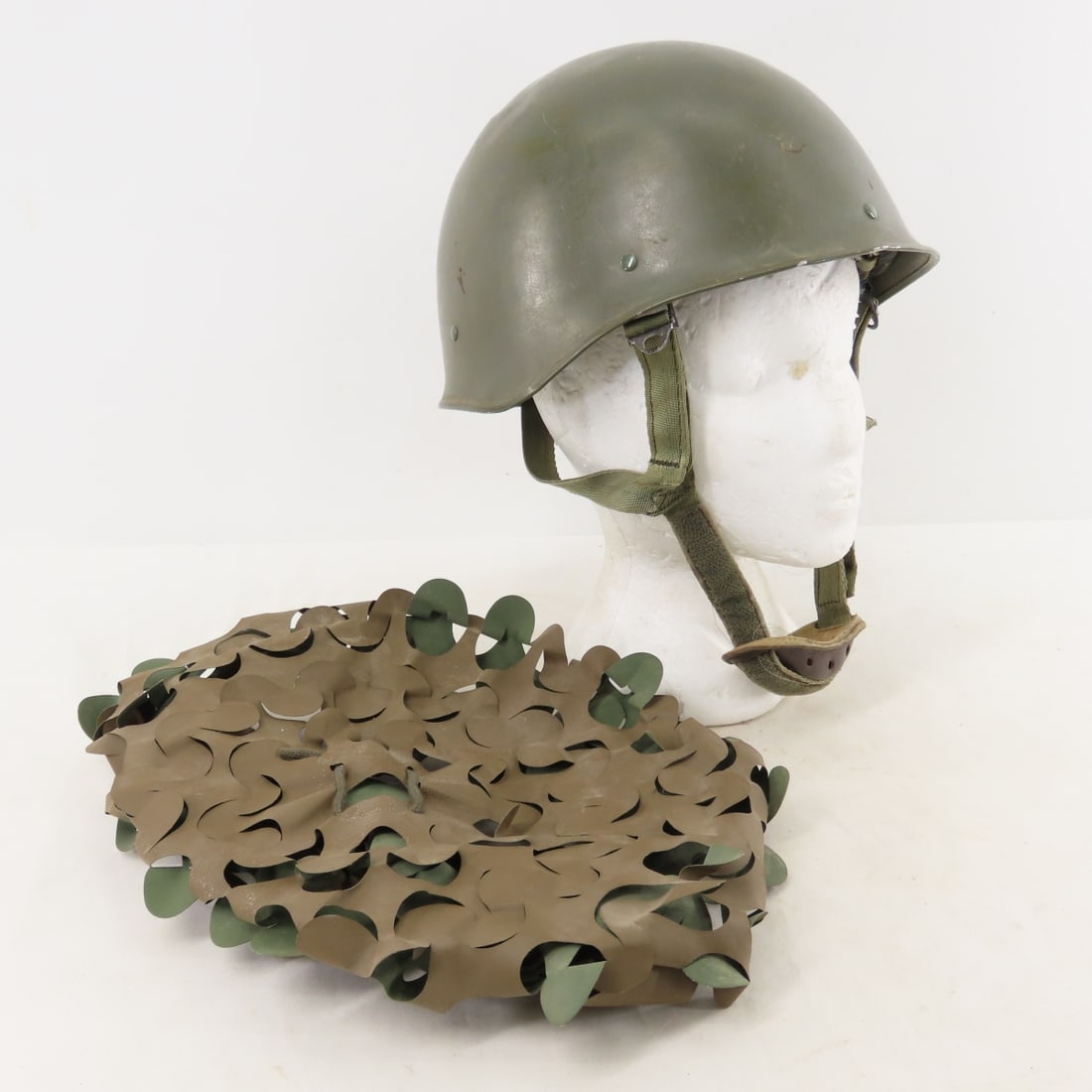French Military Model F1 Paratrooper Helmet: French Military Model F1 Paratrooper Helmet - With camouflage Helmet Cover. Several Dents. Lot Size: 12 x 8 x 8", 3 lbs All information and photos are intended to be as accurate as possible, but error