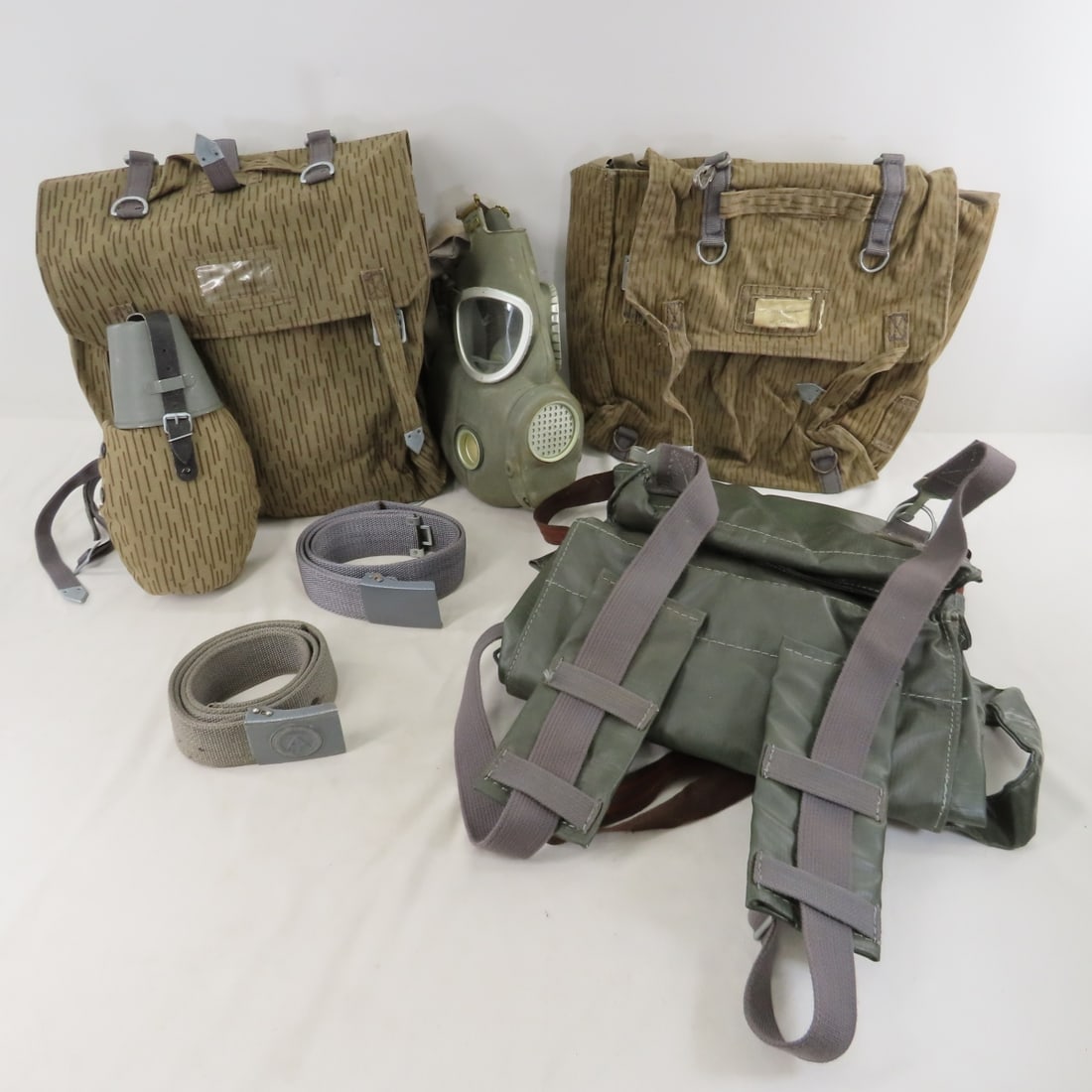Vintage E German NVA Gas Mask, Rucksack & More: Vintage E German NVA Gas Mask, Rucksack & More - Combat Backpack, Belt Buckle, Gas Mask, Canteen Set, AK-47 Magazine Pouch, Grenade Pouch, cold Weather Collar, Suspenders, Rucksack. Lot Size: 18 x 15