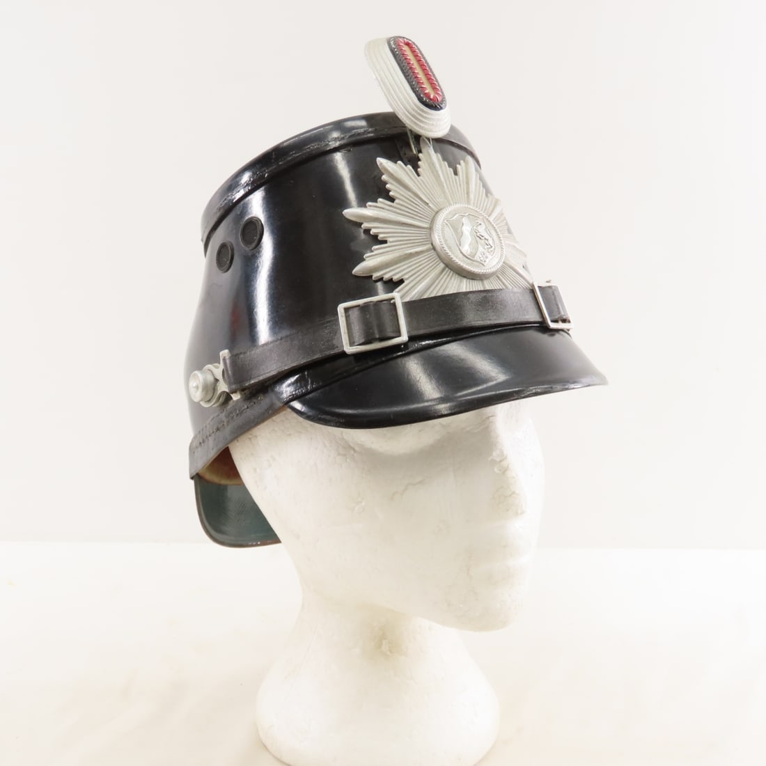 Post WWII German Westfalen Police Tschako Helmet: Post WWII German Westfalen Police Tschako Helmet - With Starburst Insignia & Cockade. Lot Size: 10 x 8 x 6", 1 lb All information and photos are intended to be as accurate as possible, but errors are