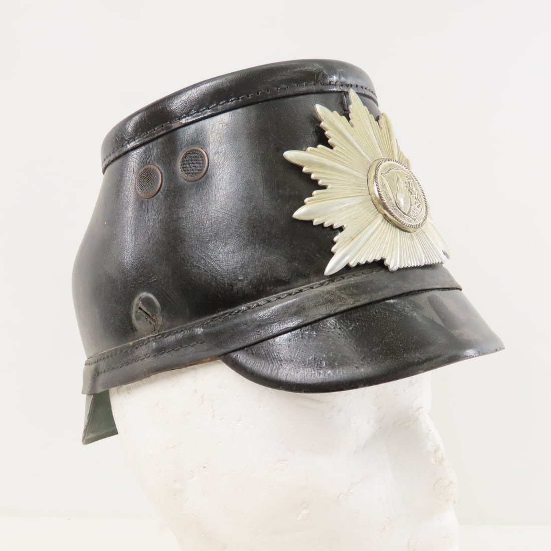 Post WWII German Police Tschako Helmet: Post WWII German Police Tschako Helmet - German Police Tschako or Shako Helmet with Starburst Insignia. Liner is heavily damaged. Lot Size: 10 x 6 x 6", 1 lb All information and photos are intended