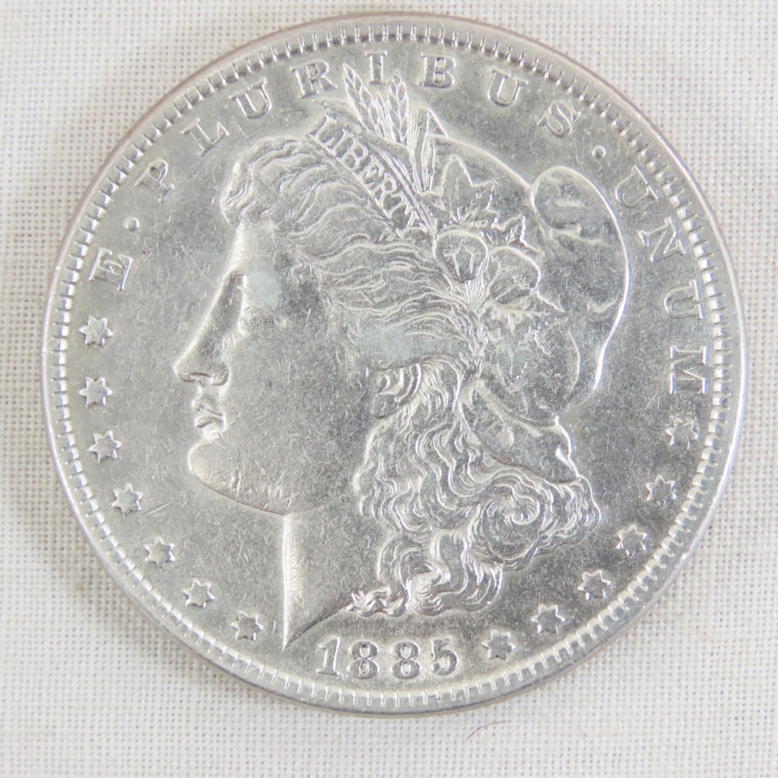 1885 Morgan Silver Dollar: 1885 Morgan Silver Dollar - Lot Size 2x2x1" 1 LB All information and photos are intended to be as accurate as possible, but errors are possible. No item may be returned or refused based on this