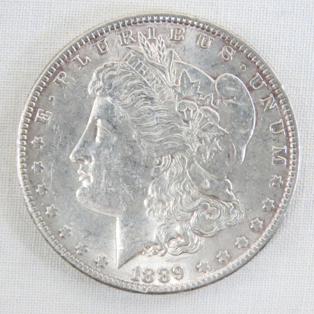 1889 Morgan Silver Dollar: 1889 Morgan Silver Dollar - Lot Size 2x2x1" 1 LB All information and photos are intended to be as accurate as possible, but errors are possible. No item may be returned or refused based on this