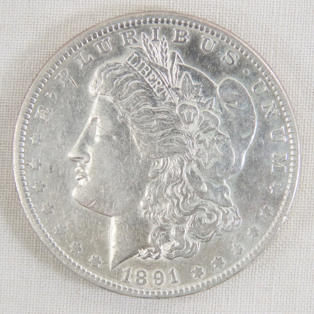 1891 Morgan Silver Dollar: 1891 Morgan Silver Dollar - Lot Size 2x2x1" 1 LB All information and photos are intended to be as accurate as possible, but errors are possible. No item may be returned or refused based on this