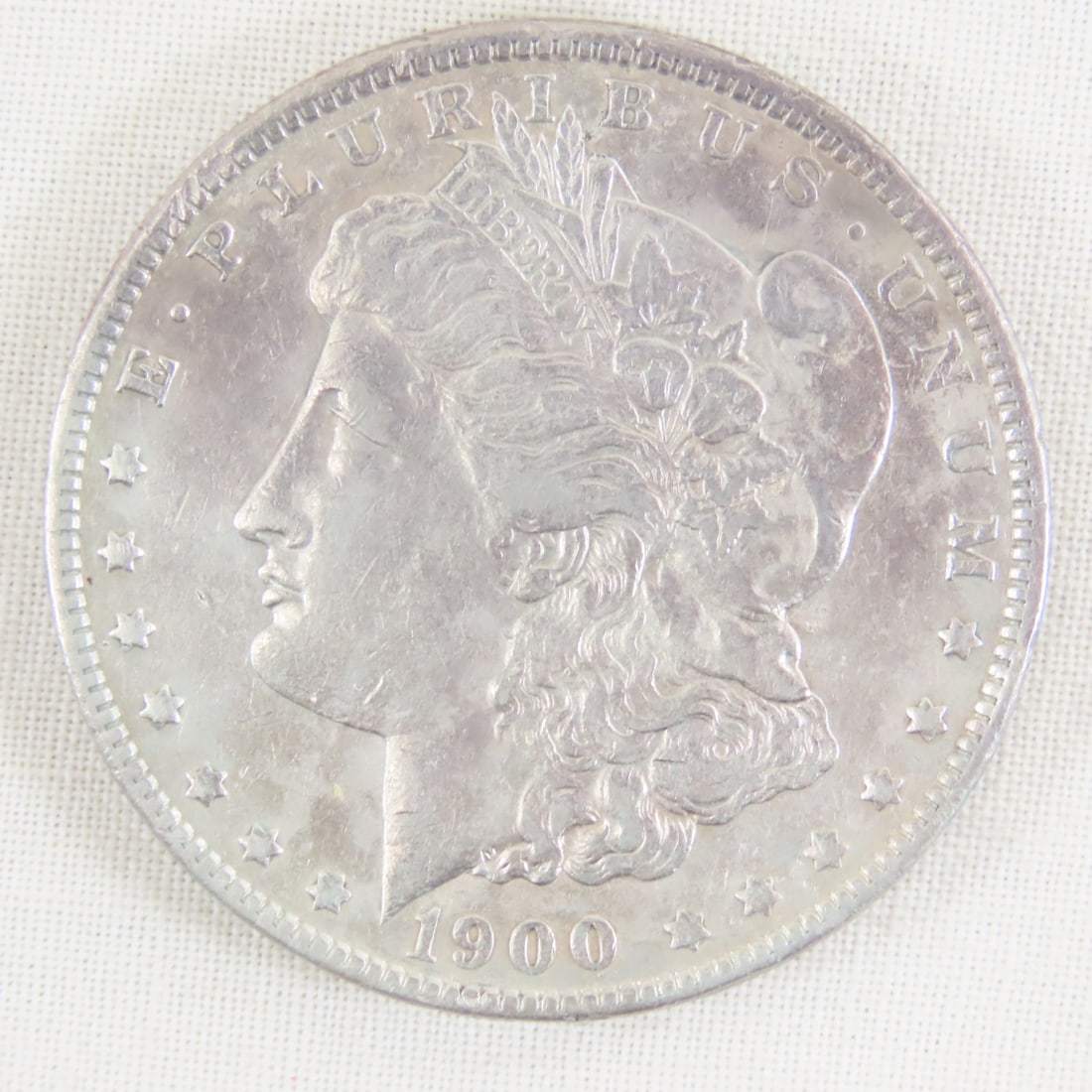 1900 Morgan Silver Dollar: 1900 Morgan Silver Dollar - Lot Size 2x2x1" 1 LB All information and photos are intended to be as accurate as possible, but errors are possible. No item may be returned or refused based on this inform