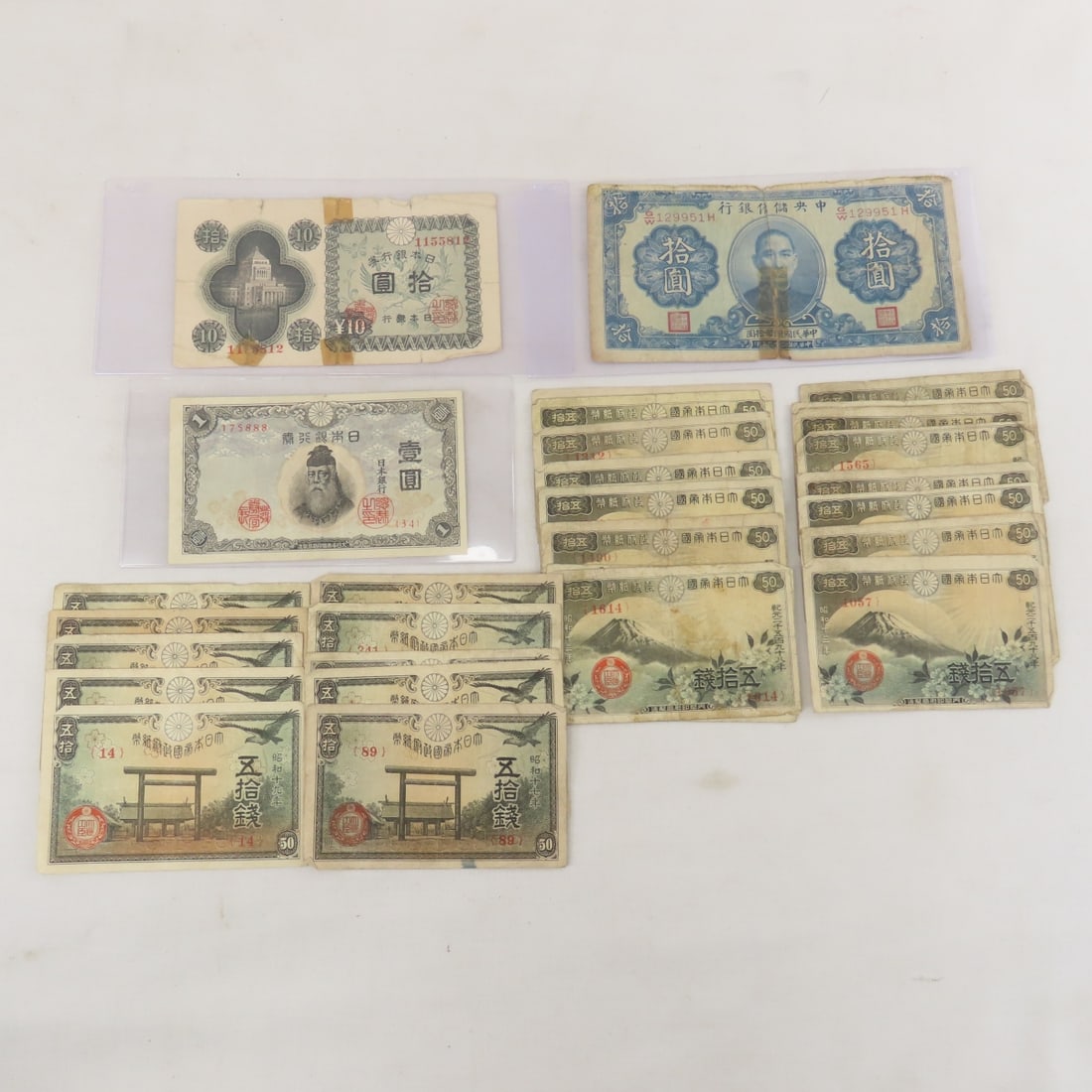 30+ WWII Japanese Currency Notes: 30+ WWII Japanese Currency Notes - 10 Yasukuni Shrine 50 Sen, 20 Mt Fuji 50 Sen, 1 Yen, 10 Yen, & 10 Yuan notes. Lot Size 8x4x1" 1 LB All information and photos are intended to be as accurate as