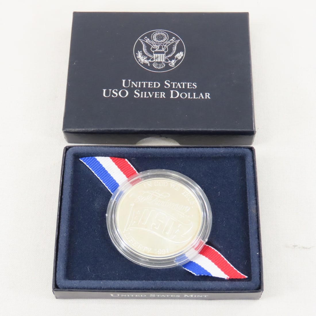 1991 USO 50th Anniversary Silver Dollar UNC: 1991 USO 50th Anniversary Silver Dollar UNC - with box. Lot Size 4x3x1" 1 LB All information and photos are intended to be as accurate as possible, but errors are possible. No item may be returned or