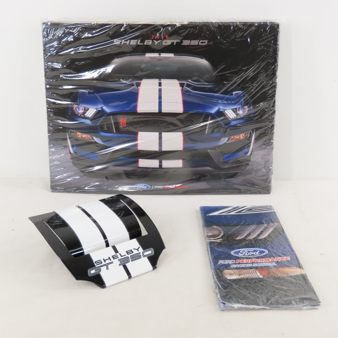 50 Shelby GT 350 2018 Brochures & Card Holder: 50 Shelby GT 350 2018 Brochures & Card Holder - dealer brochures in sealed plastic, small sealed pack of Ford performance racing school brochures & black metal business card holder. LOT SIZE: