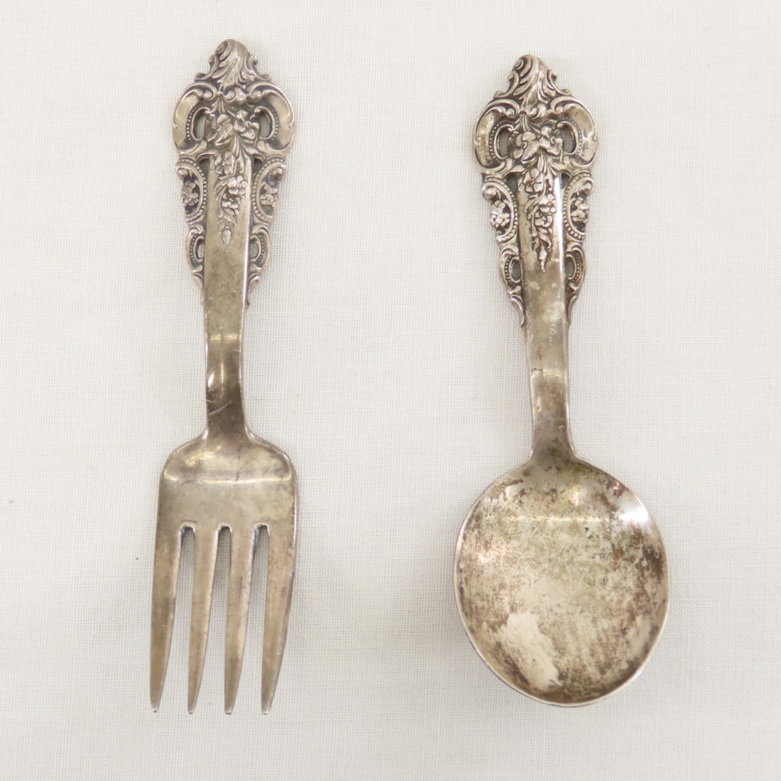 Grand Baroque Wallace Sterling Childs Fork & Spoon: Grand Baroque Wallace Sterling Childs Fork & Spoon - 1.6 Ounces, need cleaning. LOT SIZE: 5x2x2", 1 LB All information and photos are intended to be as accurate as possible, but errors are possible.
