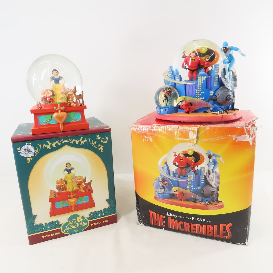 Disney Snow White & The Incredibles Snow Globes: Disney Snow White & The Incredibles Snow Globes - Disney Store Art of Snow White snow globe in box, Disney Store The Incredibles snow globe- in box (some damage to box. LOT SIZE 10x10x19", 10 LBS All 