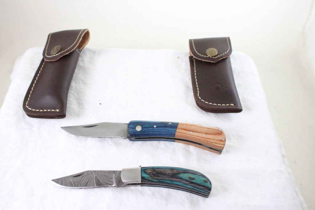 2 Unbranded Damascus Folding Knives w/Sheaths: 2 Unbranded Damascus Folding Knives w/Sheaths - Lot Size 6" x 5" x 2". 1 Lb. All information and photos are intended to be as accurate as possible, but errors are possible. No item may be