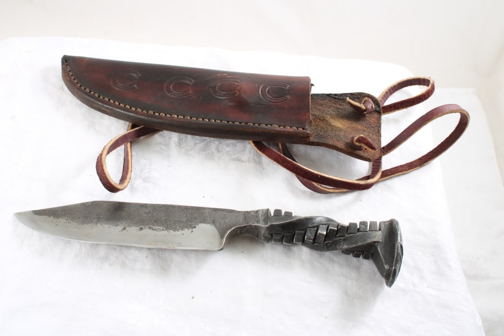 Hand Forged Railroad Spike Knife in Sheath: Hand Forged Railroad Spike Knife in Sheath - Lot Size 10" x 3" x 2". 1 Lb. All information and photos are intended to be as accurate as possible, but errors are possible. No item may be retu