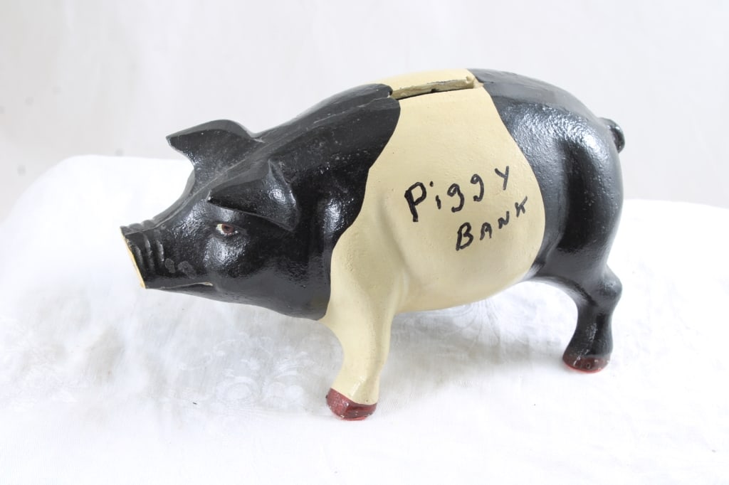 Cast Iron Piggy Bank Black and Tan with Plug: Cast Iron Piggy Bank Black and Tan with Plug - Lot Size 8" x 4.5" x 4.5". 4 Lbs. All information and photos are intended to be as accurate as possible, but errors are possible. No item