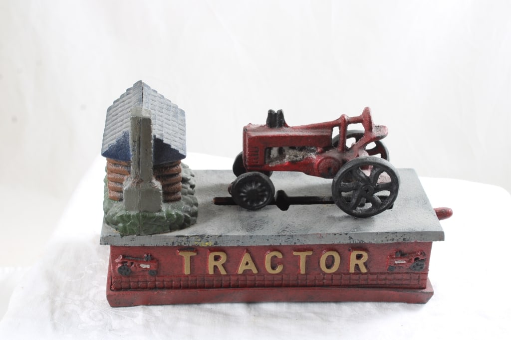 Cast Iron Tractor Mechanical Bank Works: Cast Iron Tractor Mechanical Bank Works - repro, Lot Size 8" x 6" x 3". 6 Lbs. All information and photos are intended to be as accurate as possible, but errors are possible. No item may be