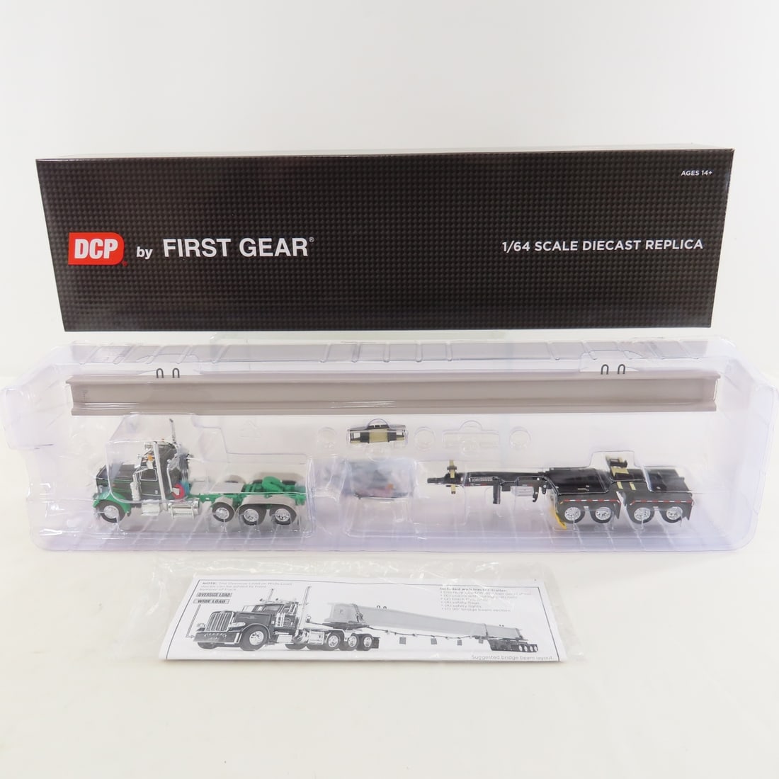 DCP First Gear 1:64 Peterbilt 389 w Beam Load: DCP First Gear 1:64 Peterbilt 389 w Beam Load - Black/Green 60-1673 1/64 Peterbilt Model 389 Tri-Axle Day Cab & ERMC 4-Axle Hydra-Steer Trailer with Beam Load. Lot Size: 19x4x3" 1 lb All information a