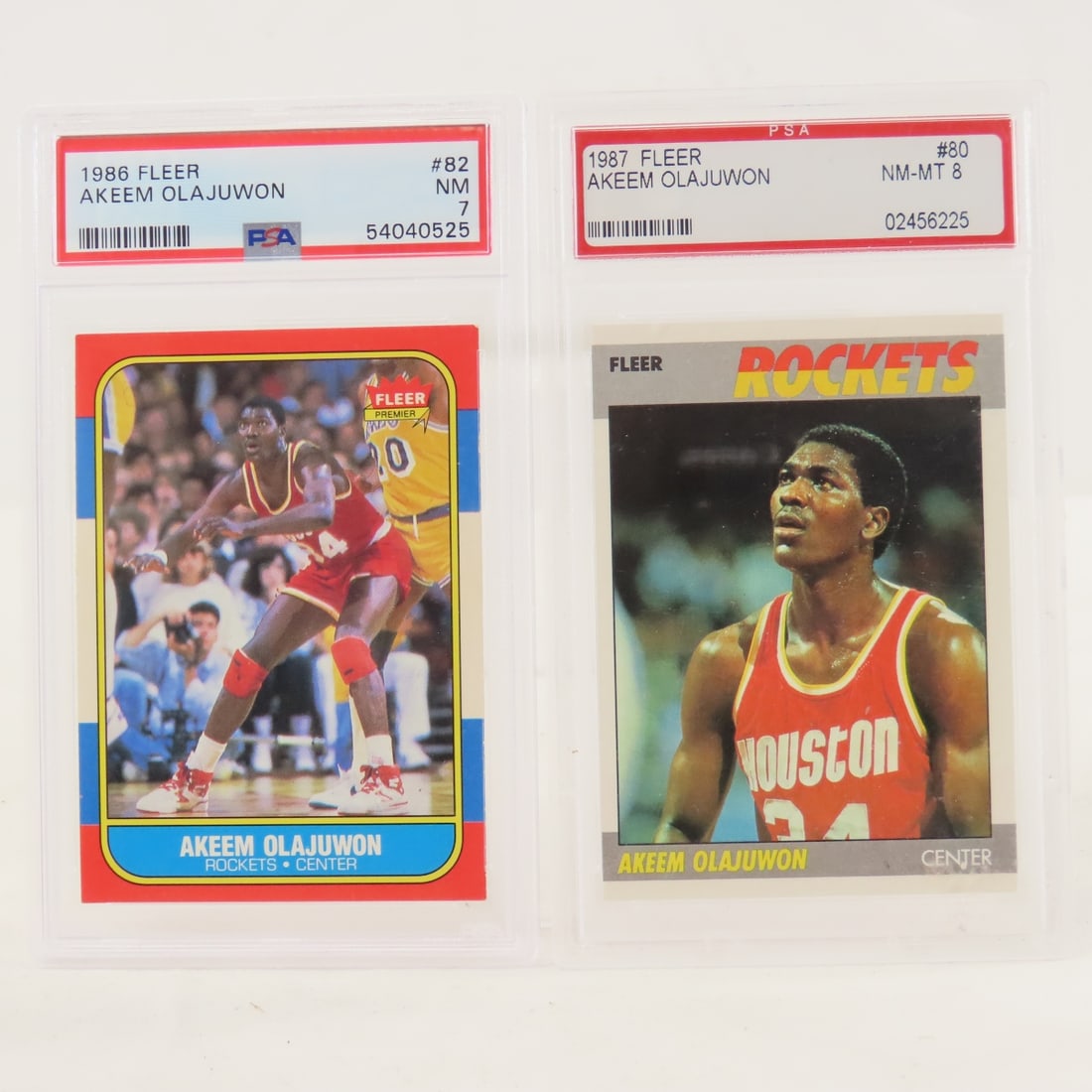 1986 Fleer Akeem Olajuwon #82 PSA 7 NM Rookie: 1986 Fleer Akeem Olajuwon #82 PSA 7 NM Rookie - And 1987 Fleer Akeem Olajuwon #80 PSA 8 NM-MT Lot Size 5.5x3.5x.5" 1 LB All information and photos are intended to be as accurate as possible, but