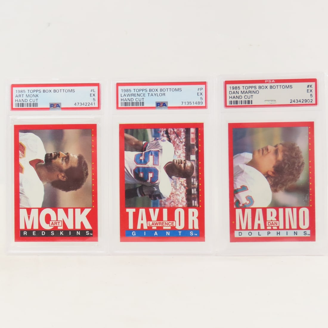 3 1985 Topps Box Bottoms Football Cards PSA 5 EX: 3 1985 Topps Box Bottoms Football Cards PSA 5 EX - 1985 Topps Box Bottoms Dan Marino #K PSA 5 EX, 1985 Topps Box Bottoms Art Monk #L PSA 5 EX, 1985 Topps Box Bottoms Lawrence Taylor PSA 5 EX. Lot Size