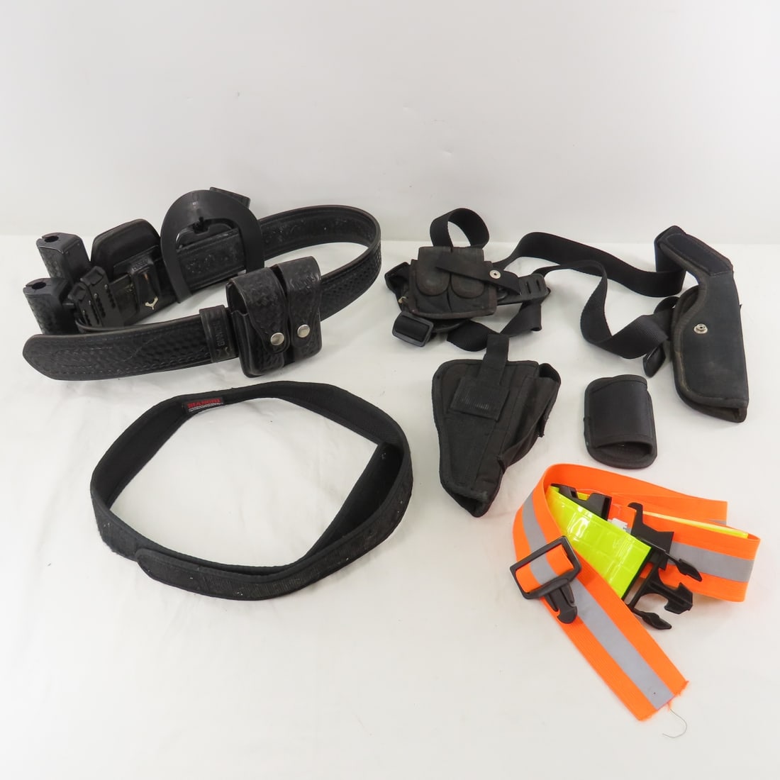 Law Enforcement Belt w/Holsters & Attachments: Law Enforcement Belt w/Holsters & Attachments - Safariland Leather Belt sz 36, Bianci 9MM Magazine Pouch, Handcuff & Baton Holders, Bulldog & Sidekick Nylon Holsters and More. LOT SIZE: 12x12x8" 3