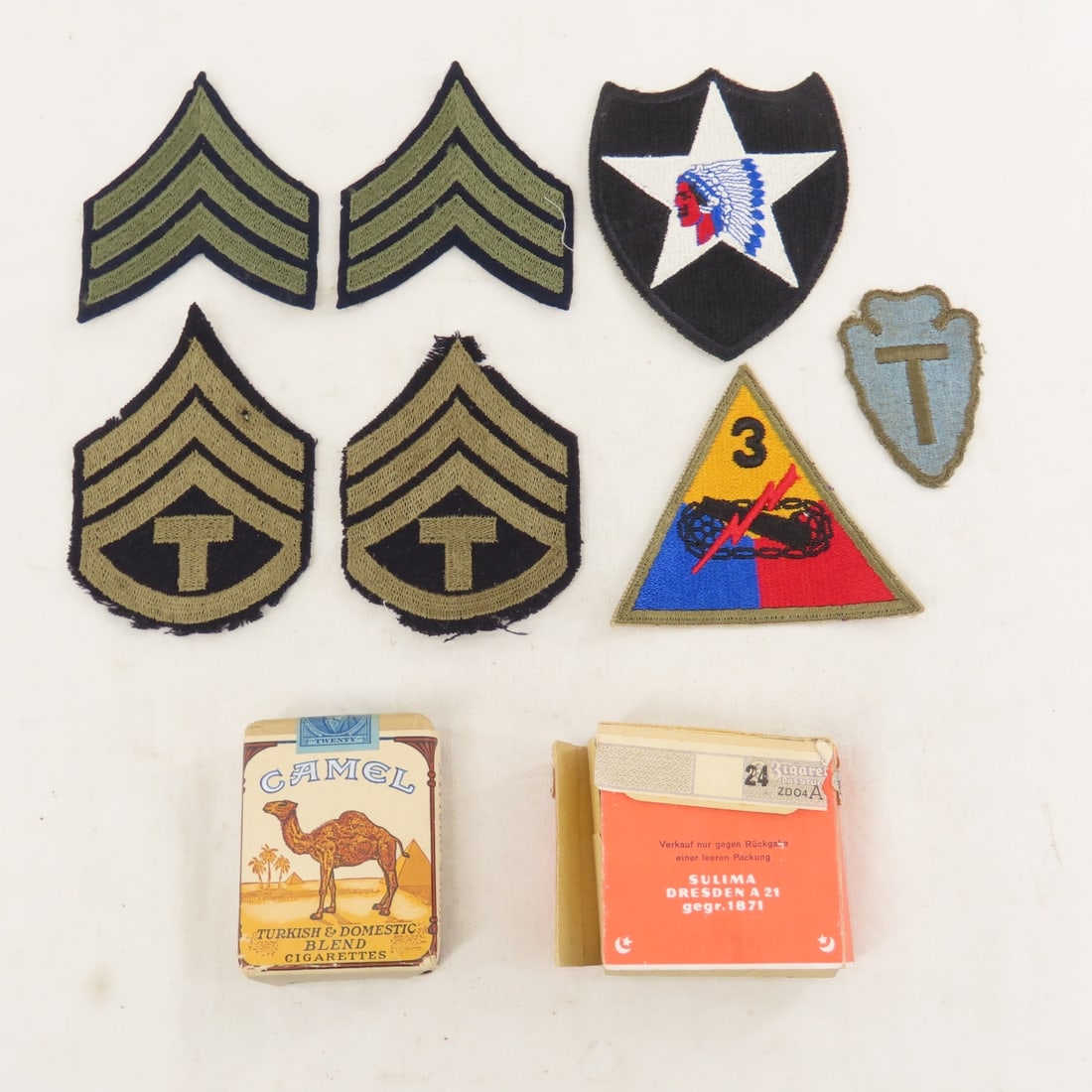 WWII US Army Patches, Camel & German Cigarettes: WWII US Army Patches, Camel & German Cigarettes - sealed pack of Camel cigarettes, full pack of German Sulima cigarettes with Eagle stamps is open but full. LOT SIZE: 5x4x2" 1 LB All information and