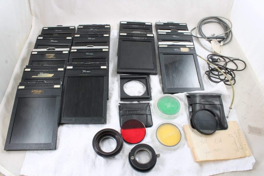 14 4x5 Film Camera Holders & Accessories: 14 4x5 Film Camera Holders & Accessories - Some of the holders have film in them. Lot Size 12" x 7" x 7". 8 Lbs. All information and photos, which are part of the description, are intended to be as