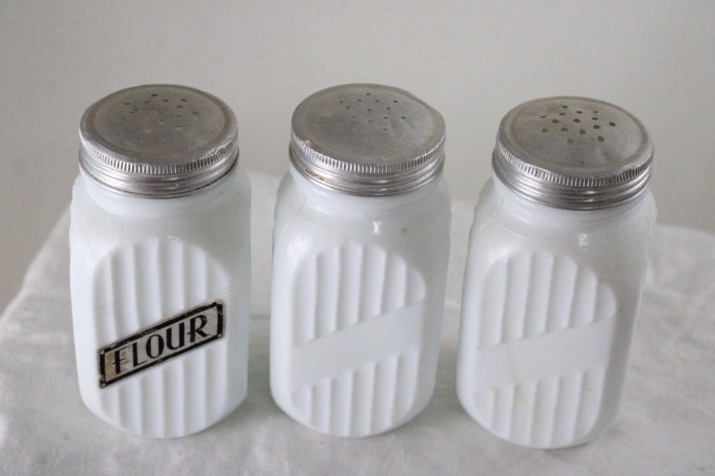 3 Milk Glass Ribbed Shakers: 3 Milk Glass Ribbed Shakers - One is marked Flour and the other 2 are plain. Lot Size 6" x 8" x 3". 2 Lbs. All information and photos, which are part of the description, are intended to be as