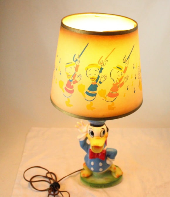 Vintage Walt Disney Donald Duck Lamp & Shade: Vintage Walt Disney Donald Duck Lamp & Shade - Works. Bulb not included. Shade has a small tear as pictured. Lot Size 12" x 12" x 10". 2 Lbs. All information and photos, which are part of the