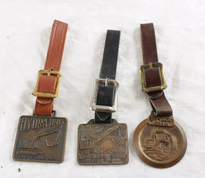 Bucyrus Hydra-Unit & American Hoist Watch Fobs: Bucyrus Hydra-Unit & American Hoist Watch Fobs - Lot Size 5" x 3" x 3". 1 Lb. All information and photos, which are part of the description, are intended to be as accurate as possible, but errors are