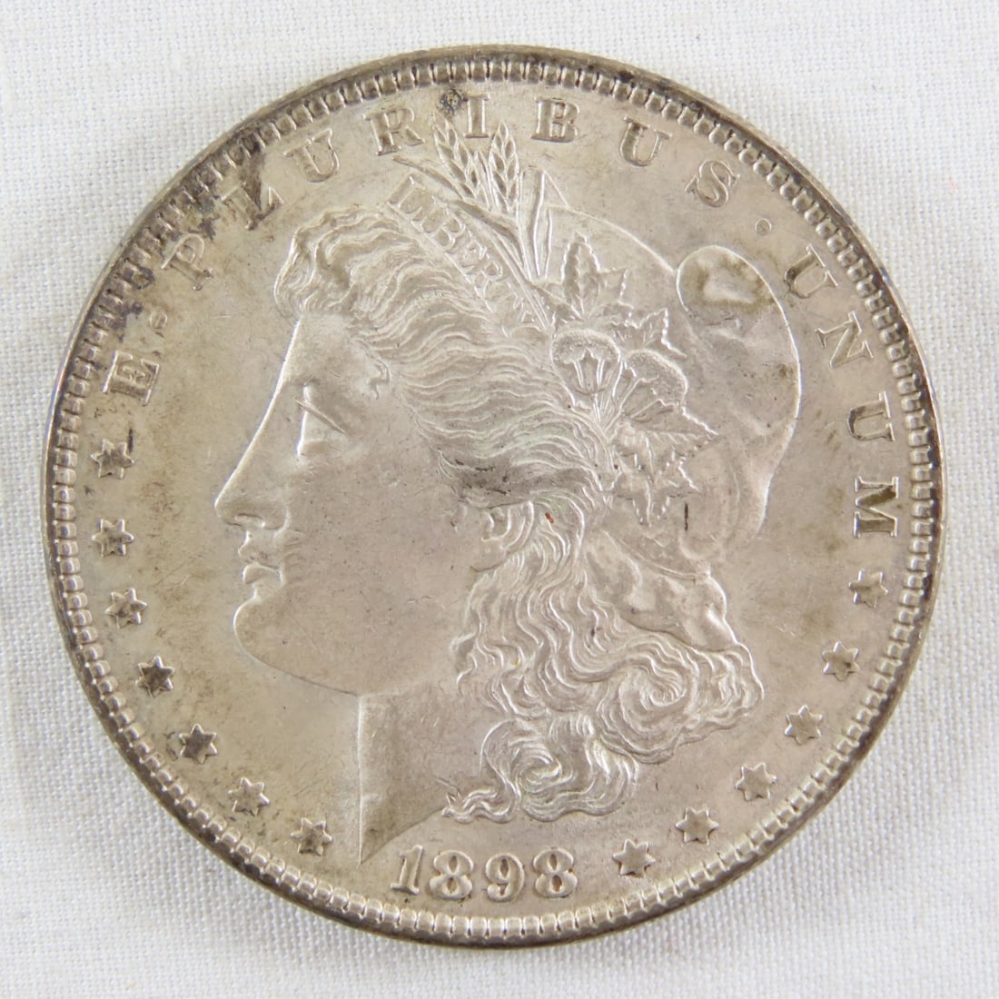 1898 Morgan Silver Dollar: 1898 Morgan Silver Dollar - LOT SIZE: 2x2x1" 1 LB All information and photos, which are part of the description, are intended to be as accurate as possible, but errors are possible. No item may be
