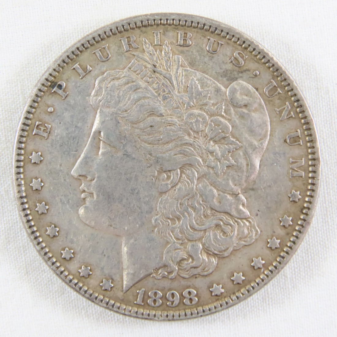 1898 Morgan Silver Dollar: 1898 Morgan Silver Dollar - LOT SIZE: 2x2x1" 1 LB All information and photos, which are part of the description, are intended to be as accurate as possible, but errors are possible. No item may be