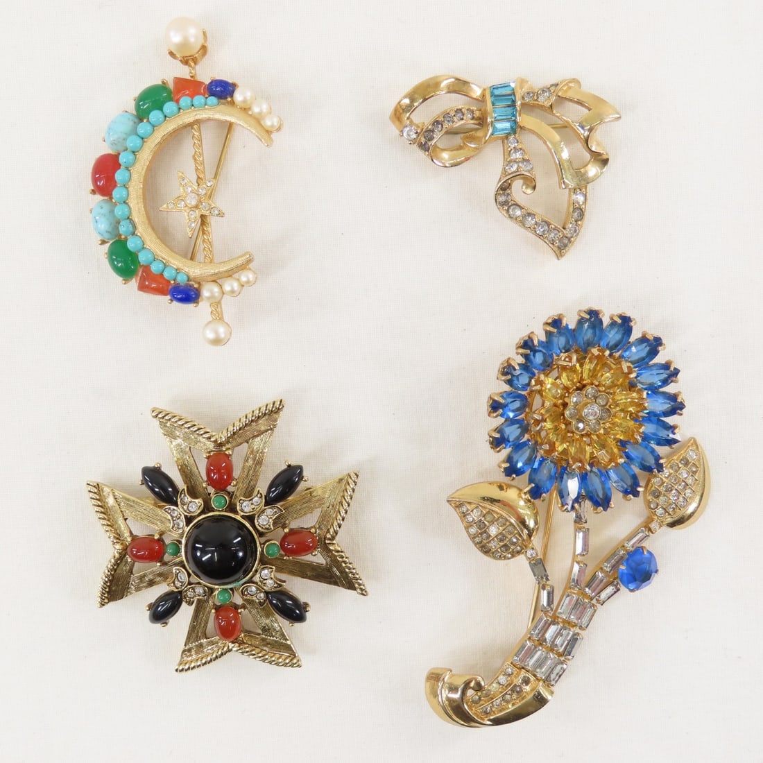 4 Unsigned Vintage Brooches: 4 Unsigned Vintage Brooches - in the style of Trifari and other era designers. LOT SIZE: 6xx4x2" 1 LB All information and photos, which are part of the description, are intended to be as accurate as