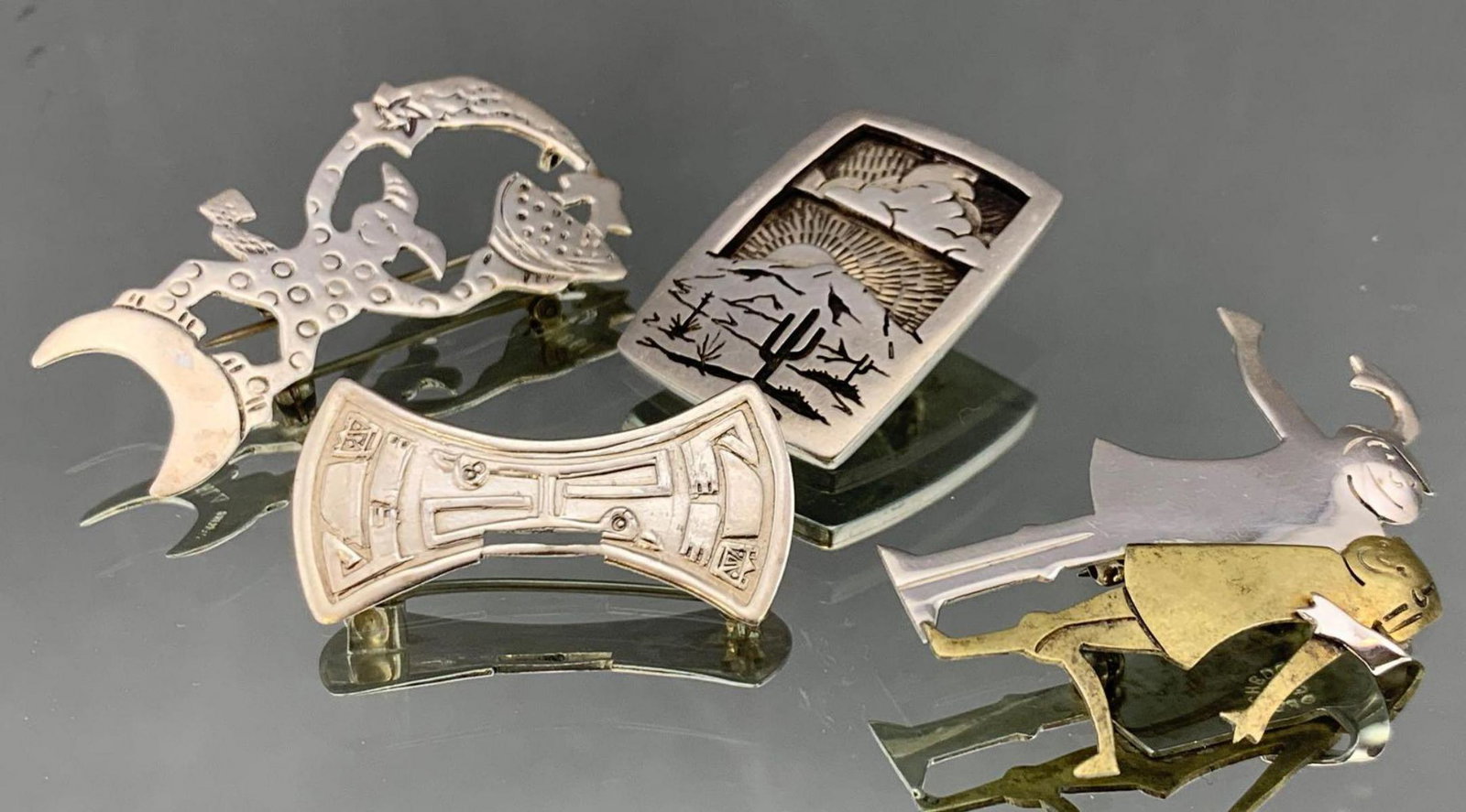 Four Vintage Sterling Silver Taxco Jewelry Pieces: Four sterling silver Taxco jewelry pieces, 29g. Clown pin/pendant hallmarked RL sterling 1987 2 x 1in. Sterling and copper friends pin hallmarked Far Fetched .925, 2 x 1.75 in. South west sunset penda