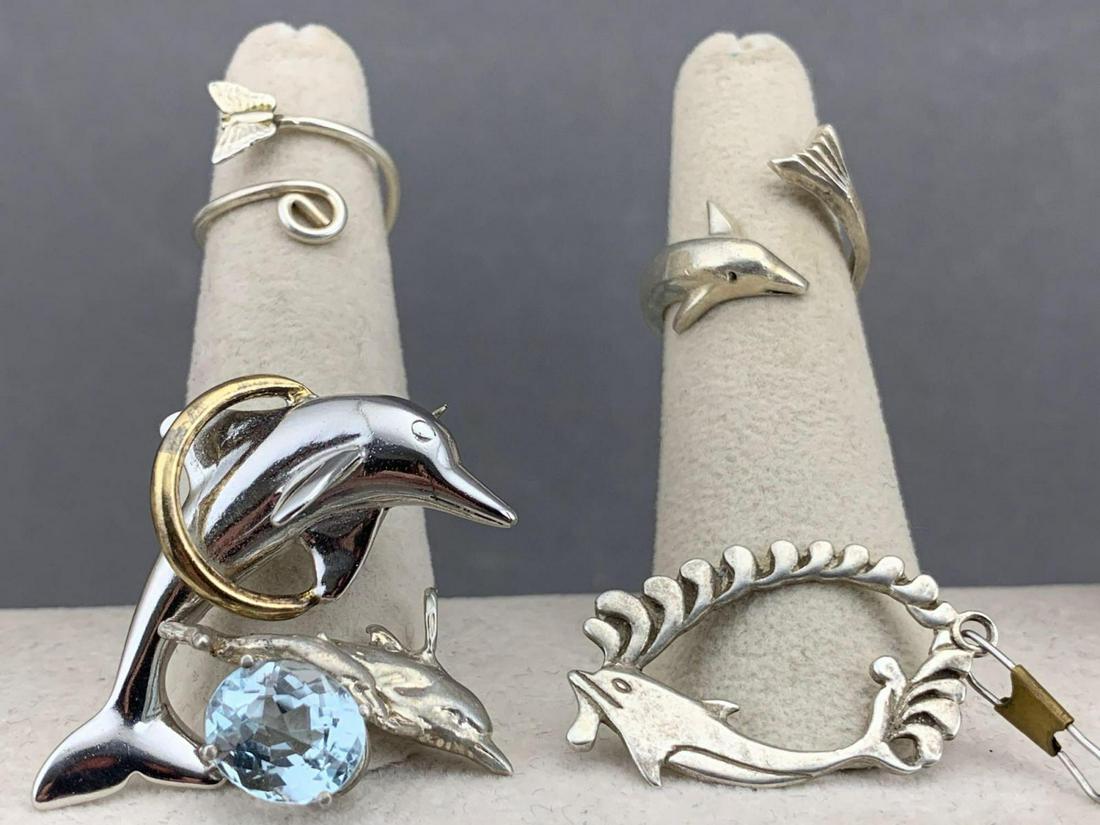 Sterling Silver Dolphin Jewelry Lot: Sterling silver jewelry lot of 5, including 2 rings, 2 pendants and 1 pin, 17.9 g., ring sizes 3 and 5, large pendant measures approximately 1.5 x .75 in., pin measures approximately 1.5 x .5 in. All