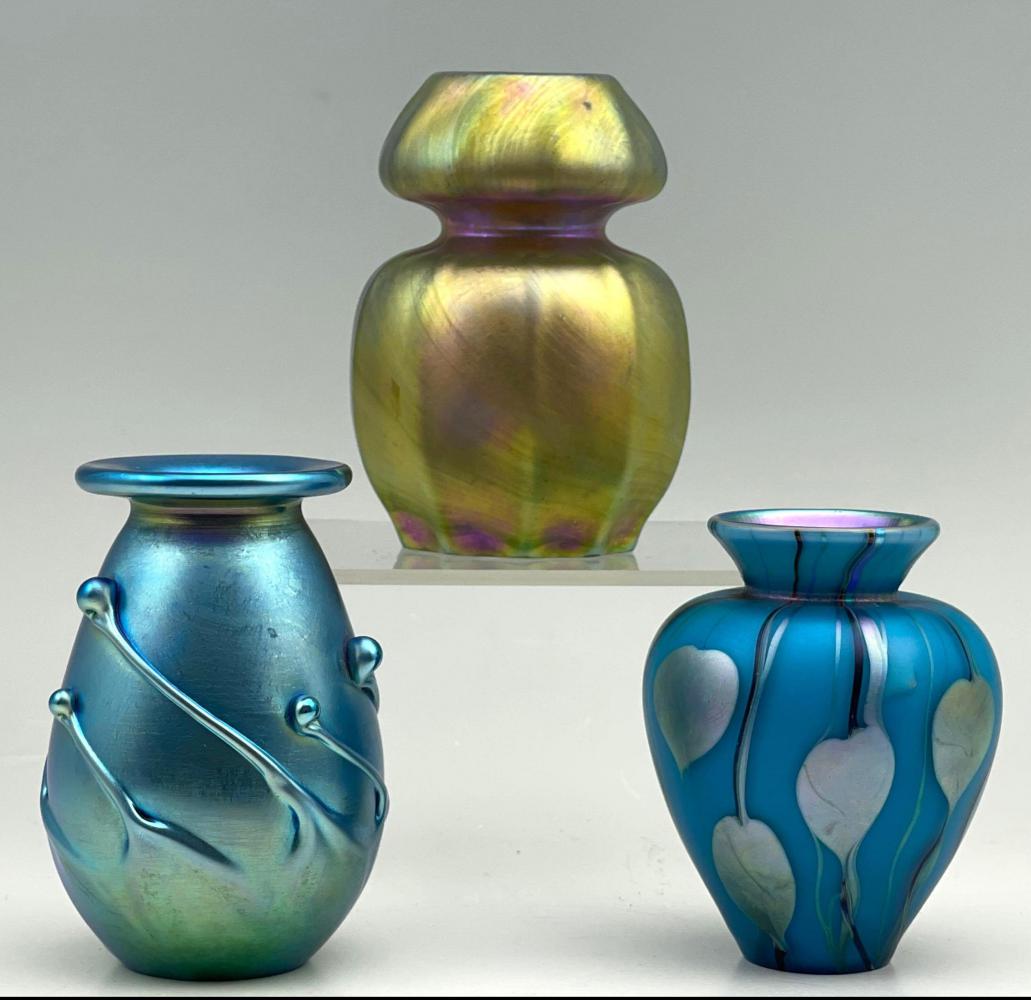 3 Iridescent Art Glass Vases: 3 Iridescent Art Glass Vases. Signatures include Lundburg studios, 1995, in. Cantor, Made in Davenport, California, Christmas, Orlando's. 1977. Approximately 3 x 2 x 1 in. - 3.5 x 2 x 1.5 in. - 3 x