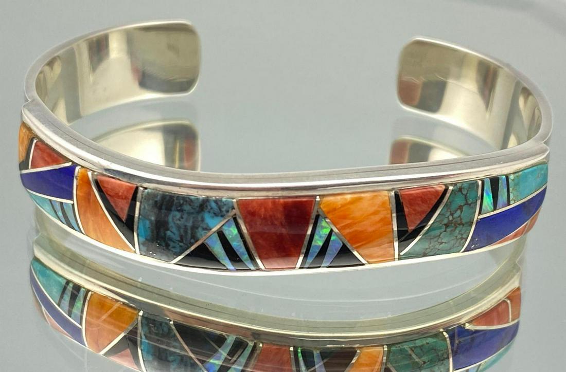 Navajo Sterling Silver Cuff with Inlaid Opal,: Navajo Sterling Silver Cuff with Inlaid Opal, Turquoise, Spiny Oyster, Black Onyx, and Lapis by Kenneth Bitsie. 30.7g, inside 5.125, cuff break 1.0625 in. Signed Kenneth Bitsie, marked Sterling.