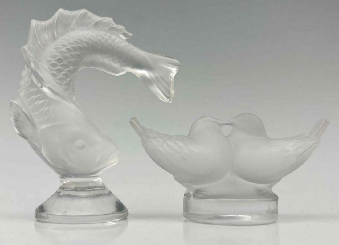 2 Hand Signed Lalique Crystal Figurines: 2 Hand Signed Lalique Crystal Figurines Of Jumping Fish And Kissing Doves. Marked Lalique France. Fish Approximately 3.5H x 2.5W x 1.25D in. Doves Approximately 1.5H x 3.0W x 1.25D in.
