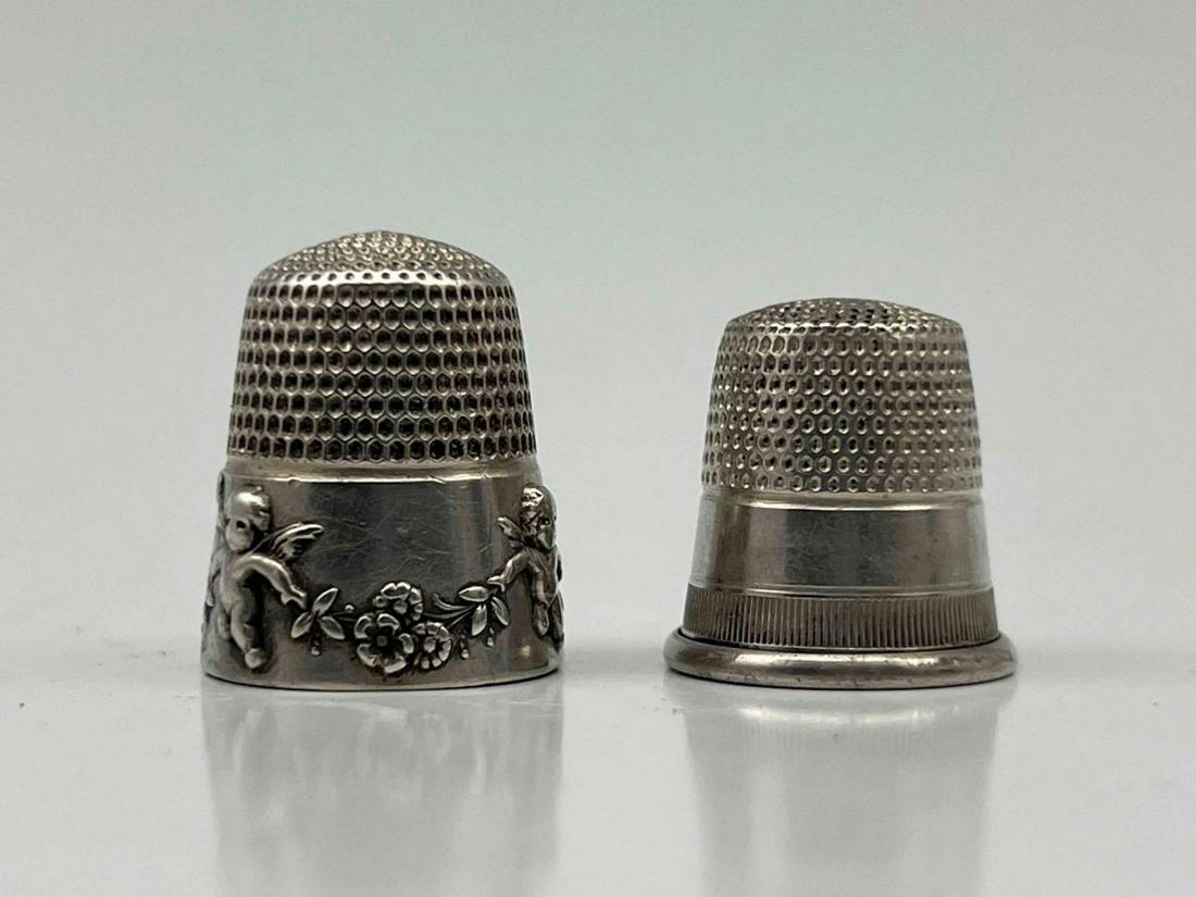 Two Sterling Silver Thimbles: Two Sterling Silver Thimbles, One With Intricate Cherub Decoration. 6.8g. Marked Sterling, Pat. Nov. 21.05. Approximately 0.75H x 0.625W in. Approximately 0.625H x 0.625W in.