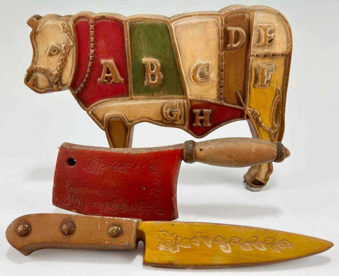Set of Three Painted Metal Butcher's Trade Signs: 3 Painted Metal Knife & Primal Cut Butcher Signs. Both Marked Midwest 89. Approximately 11.875L x 8.375W x 0.75D in. Approximately 10.0L x 3.5W x 0.626D in. Approximately 11.875L x 1.625W x 0.75D in.