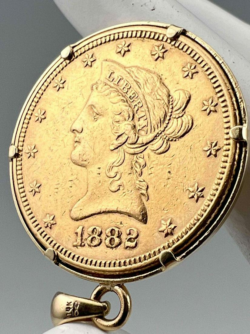 Gold 1882 US10 Dollar Liberty Coin, Set In 14K Bezel: Gold 1882 US10 Dollar Liberty Coin, Set In 14K Bezel, 18.8g. Bale Marked 14K. Coin Marked "United States Of America, 10D, 1882." Approximately 1.125L x 1.125W in. ALL CREDIT CARDS WILL BE MANUALLY VER
