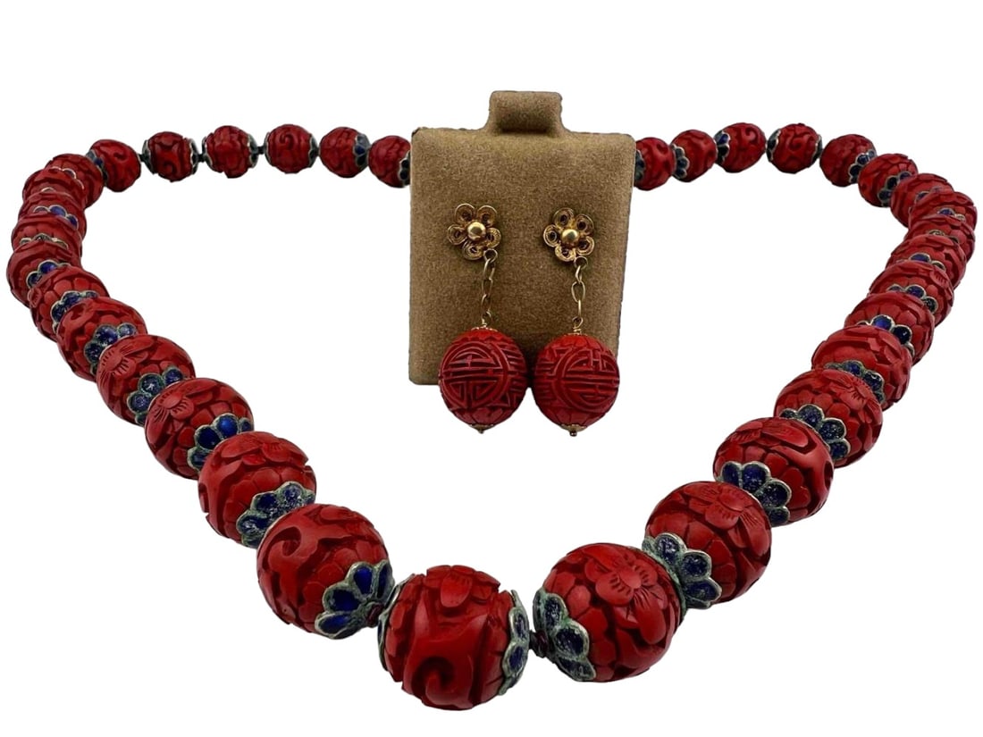 Chinese Cinnabar Shou Bead Necklace and Earrings: Chinese Carved Cinnabar Enamel Necklace & Earrings. Tag on back of earrings marked "Cinnabar Happiness/Luck Symbols W/ Vermeil Ear Posts." Necklace 28.75L x 0.625W in. Earrings 1.625L x 0.5625W in. Al
