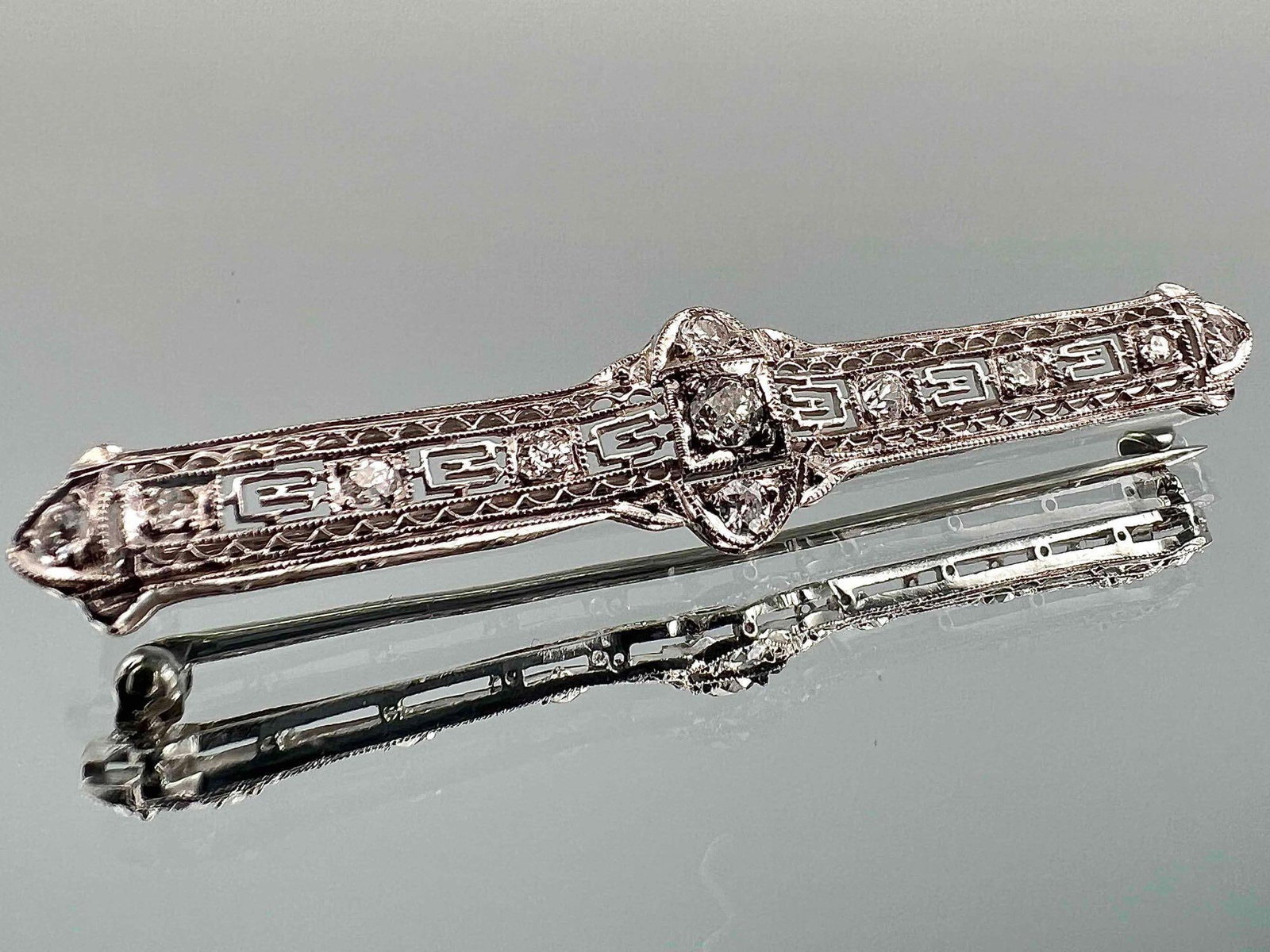 Platinum & Diamond Art Deco Filigree Brooch: Platinum & Diamond Art Deco Filigree Brooch, 3.8g. Unmarked, tests as platinum. Approximately 2.0W x 0.375W in. ALL CREDIT CARDS WILL BE MANUALLY VERIFIED PRIOR TO SHIPMENT,